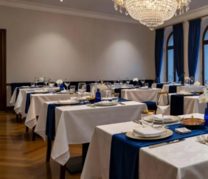 Salle de restaurant gastronomique avec nappes ivoire, chandeliers et éclairage chaleureux